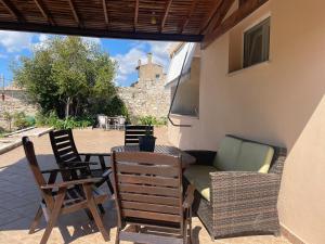 a patio with chairs and a couch and a table at House Garden in Kalamoti in Kalamoti