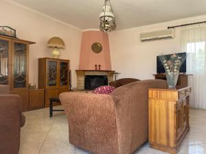 a living room with a couch and a fireplace at House Garden in Kalamoti in Kalamoti