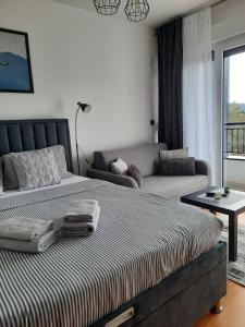 Apartman Pogled Divcibare في ديفشيبار: غرفة نوم بها سرير كبير وأريكة