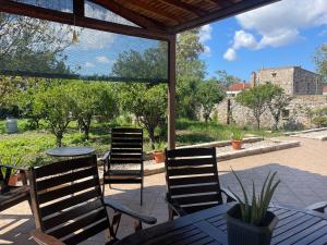 a patio with three chairs and a table with a view at House Garden in Kalamoti in Kalamoti