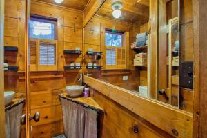 bagno con pareti in legno e grande specchio di Ray's Dear Cottage a Wrightwood Altre 113 foto