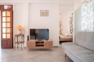 a living room with a tv and a couch at La Kaz and Ti Thano in Port-Louis