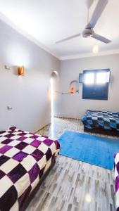 a bedroom with two beds and a checkerboard floor at Laila's Home in Siwa