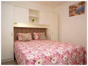 a bedroom with a large bed with pink sheets and pillows at Villa Luketini Dvori, Primošten in Kruševo +100 photos