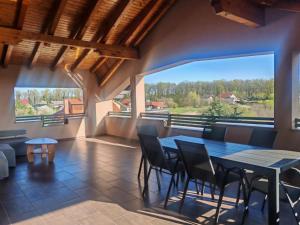 a dining room with a table and chairs and a large window at Apartman Kristian Zagreb Airport in Velika Gorica