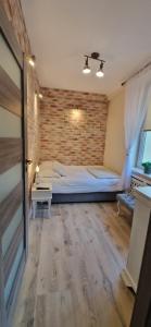 Un dormitorio con una cama y una pared de ladrillo. en Noclegi na Ogrodowej, en Sandomierz