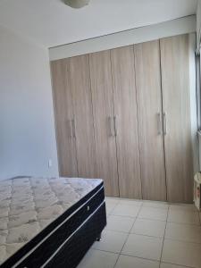 una camera con letto e armadi in legno di Apto versátio trabalho e lazer a Cuiabá