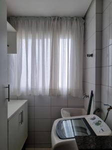 un bagno con lavandino, WC e finestra di Apto versátio trabalho e lazer a Cuiabá Altre 17 foto