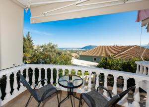 a balcony with chairs and a table with a view at A L'AISE STUDIOs in Apolpaina