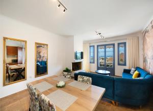 a living room with a table and a blue couch at A L'AISE STUDIOs in Apolpaina