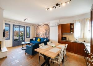 a living room with a blue couch and a table at A L'AISE STUDIOs in Apolpaina