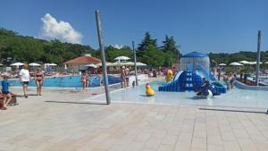 einen Wasserpark mit Leuten, die im Pool spielen in der Unterkunft Dija Riva 1 in Vabriga