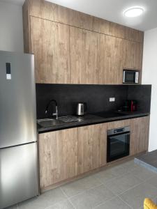 a kitchen with wooden cabinets and a stainless steel refrigerator at Apartman MINI MI 2 in Zagreb +4 photos