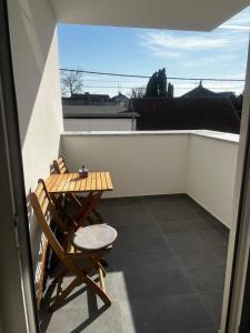 a small balcony with a wooden table and chairs on it at Apartman MINI MI 2 in Zagreb