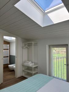 a skylight in a bedroom with a bed and a bathroom at BiancoGelso b&b Vegan in Gardone Riviera