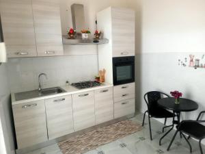 a kitchen with white cabinets and a table and a sink at Casa nel mare in Biassa