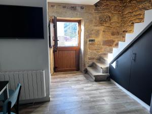 a hallway with a door and stairs with a television at Casa Cuchariños Louro in Louro