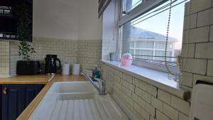 a kitchen with a sink and a window at Kabaka - Comfy Birley 3 Bedroom Home in Frecheville +22 photos