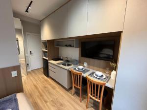 a small kitchen with a table and two chairs at Studio Moderno ao lado do Metrô Alto da Ipiranga in Sao Paulo