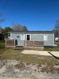una pequeña casa con porche y valla en Siblu Villages, en Lauwersoog