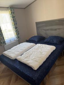 Dos camas individuales en una habitación con ventana. en Siblu Villages, en Lauwersoog