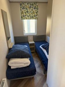 Una pequeña habitación con dos camas y una ventana. en Siblu Villages, en Lauwersoog