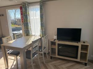 comedor con mesa y TV en un stand en Siblu Villages, en Lauwersoog