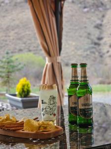 two bottles of beer sitting on a table with food at Fenix Villa in Zarritʼapʼ