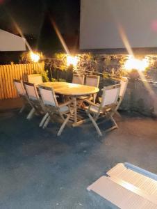 einen Holztisch und Stühle auf einer Terrasse in der Nacht in der Unterkunft Townhouse with modern mobility accessible apartment including widened doors and ramps, pets welcome, 5 bedrooms, secure off road parking, near Home Park, golf, pitch and putt, tennis courts, Argyle, eateries, microbrewery, pubs, boutique shops and salons in Plymouth + 77 Fotos