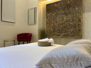 a bedroom with a white bed and a red chair at Boutique Hotel Casa Grande, Mandala Suite in Santo Domingo +24 photos