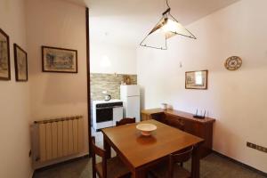 a kitchen with a wooden table and a dining room at Casa vacanza Maura relax Toscana in Crocino
