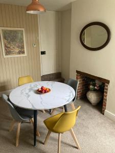 a table with chairs and a bowl of fruit on it at Painters Cottage, Grade II Listed, Salisbury in Salisbury