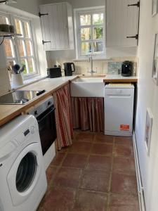 a kitchen with a washing machine and a sink at Painters Cottage, Grade II Listed, Salisbury in Salisbury