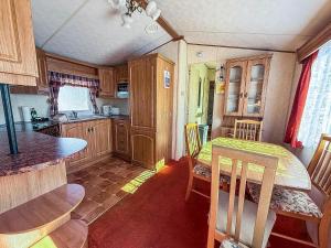a small kitchen with a table and chairs in a caravan at Great 6 Berth Caravan, Perfect For A Beach Holiday In Hunstanton Ref 13007L in Hunstanton +7 photos