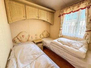 a small room with two beds and a window at Great 6 Berth Caravan, Perfect For A Beach Holiday In Hunstanton Ref 13007L in Hunstanton
