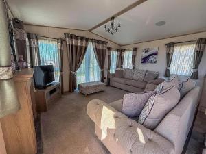 un salon avec un canapé et une télévision dans l'établissement Beautiful Lodge At Manor Park In Hunstanton Ref 23018K, à Hunstanton