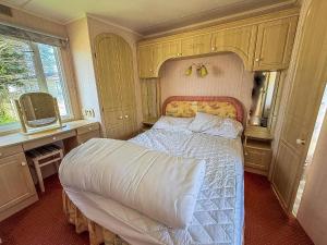 a bedroom with a bed with a white comforter at Spacious Caravan For Hire In Hunstanton At Manor Park Holiday Park Ref 23047B in Hunstanton +13 photos