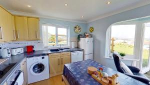 a kitchen with a washer and dryer and a table at F74 Chyandour, Riviere Towans in Hayle