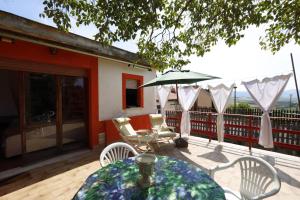 a patio with a table and chairs and an umbrella at Casa vacanza Maura relax Toscana in Crocino