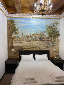 a bedroom with a large painting on the wall at Mukhlisabegim Hotel in Bukhara