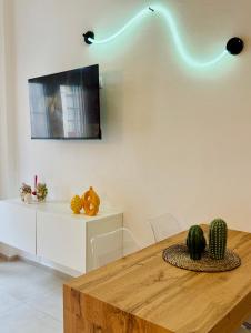 Una habitación con una mesa y un televisor en la pared. en Vittoria Apart, en Siracusa 17 fotos más