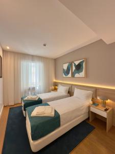 a hotel room with two beds and two tables at Timeless - Old City in Lisbon