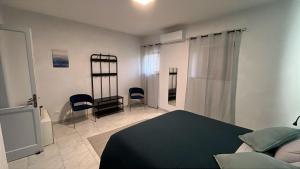 a bedroom with a bed and chairs in it at Maison Al Vecchio Cinema in Alife