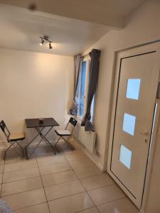 a room with a table and chairs and a door at Maison studio in Paris
