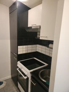 a small black and white kitchen with a sink at Maison studio in Paris