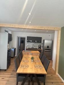 a kitchen with a wooden table with chairs and a kitchen with at Gîte 10 personnes in Baldenheim