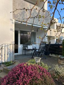 a patio with a table and chairs and flowers at Wohnen am Schloss in Wolfsburg