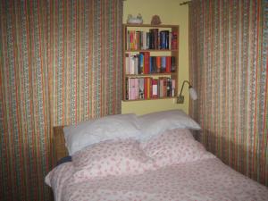 1 dormitorio con 1 cama y estantería con libros en Ferienhaus bei Berlin en Falkensee