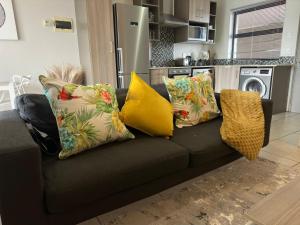 a black couch with pillows on it in a kitchen at The Cube Apartment Sandton in Johannesburg