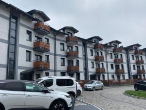 a parking lot with cars parked in front of a building at Apartament Nad Stawem in Wadowice